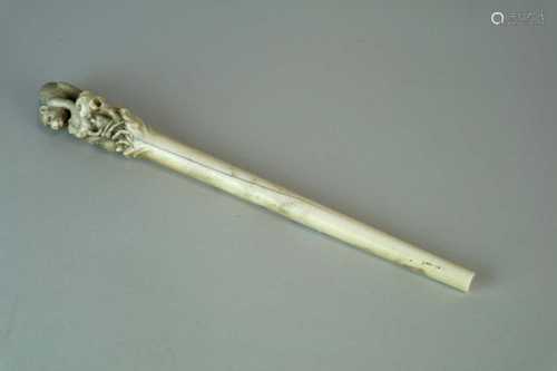 A Japanese Meiji period ivory staff, the carved terminal in the form of a monkey toiling to rescue