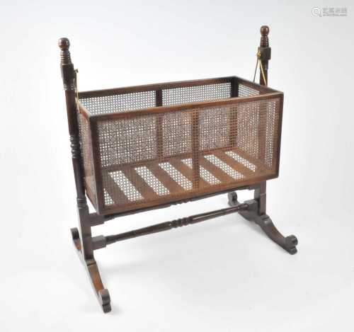 A Victorian mahogany framed bergere crib, rocking on brass mounts, 115cm high, 46cm deep, 105cm