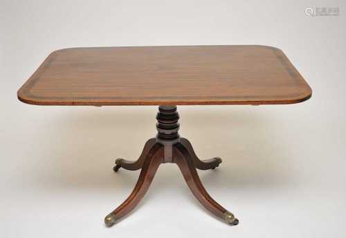 A mahogany breakfast table, with rounded rectangular top, cross-banded in rosewood, over a turned