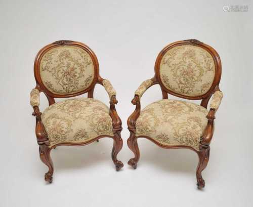 A pair of Victorian upholstered oak elbow chairs, with carved acorn motifs to the backs above