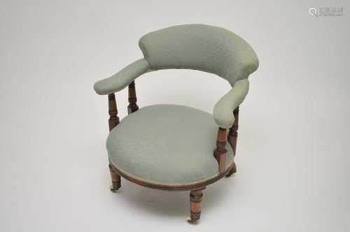 An Edwardian upholstered tub chair. with turned mahogany supports and legs on castors, 68cm high,