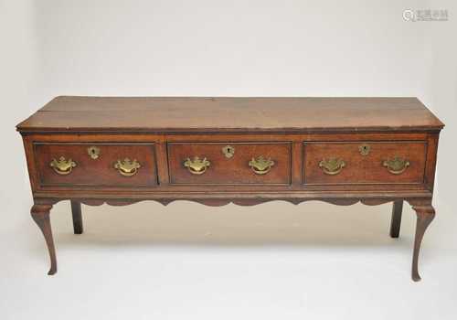 A George III country oak sideboard, the planked top over three equal drawers, fitted with brass