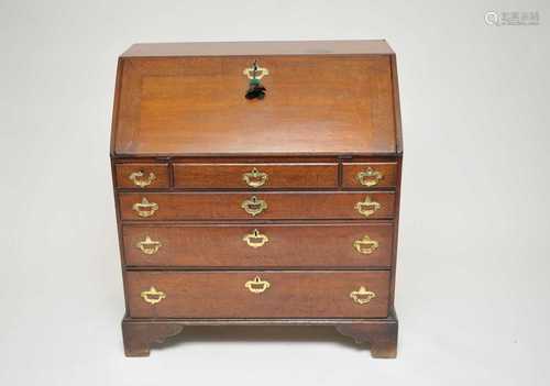 A 19th century oak bureau, with a fitted interior above an arrangement of six drawers, with brass