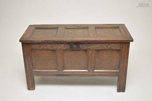 A small 18th century and later panelled oak coffer, over a foliate carved frieze, 63cm high, 114 x