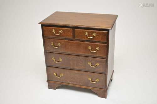 A reproduction oak chest of two short and three long drawers, of diminutive proportions, with