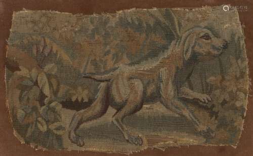 17th Century textile fragment of a dog, the dog with the front paw raised among trees and leaves,