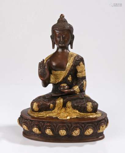 Bronze Buddha, legs crossed with hand raised with gilt heightened decoration, 26cm high