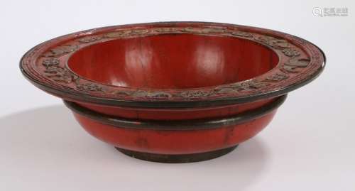 Chinese red lacquer bowl, with a bate and symbol design to the edge of the deep bowl, 30.5cm