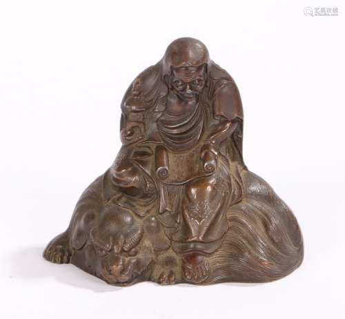 Japanese bronze effect figure, Meiji period, a seated scholar above a Komainu, 65mm diameter