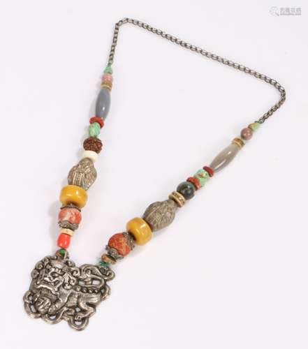 Tibetan necklace, with a dog of Foo pendant and a row of shaped and polished stones to the necklace,
