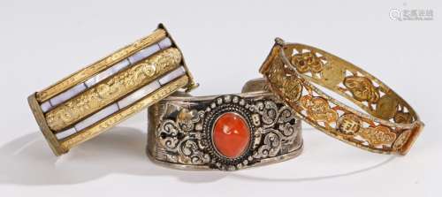 Chinese/Tibetan bangles, three examples, the first with a cabochon stone and bead surround, the