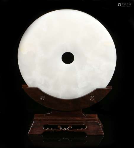 Chinese polished stone disc, of large proportions, the white stone with central hole and tapered