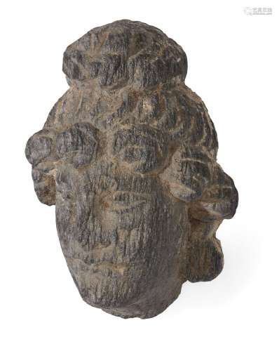 A grey schist Gandhara head of a Bodhisattva, Afghanistan, 2nd-3rd century, with full lips, hooded
