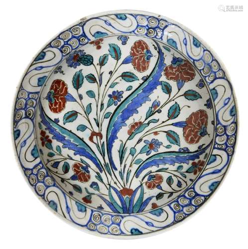 An Iznik pottery dish, Ottoman Turkey, circa 1590, with sloping rim on short foot, the white