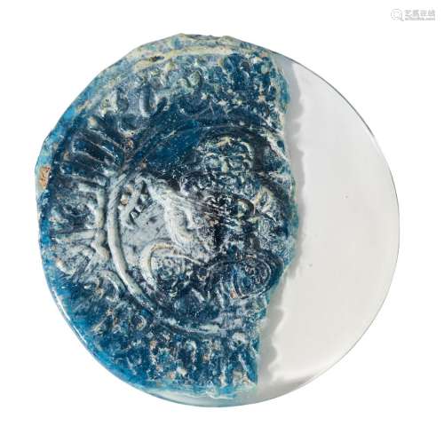 A Ghaznavid blue glass moulded roundel fragment, Iran, 12th century, of circular form, moulded