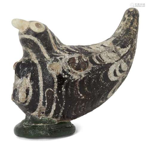 A Mamluk marvered manganese glass bird, Egypt or Syria, 10th-12th century, with wings folded