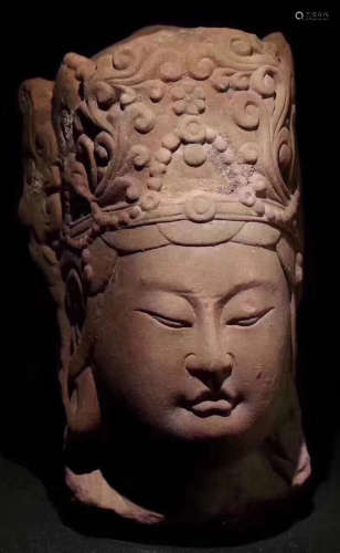 A RED STONE CARVED BUDDHA HEAD ORNAMENT