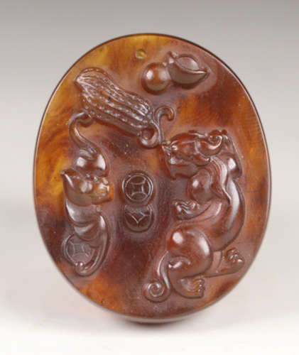 AN OLD AMBER TABLET CARVED WITH BEAST
