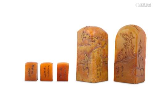 A PAIR AND A SET OF THREE CHINESE SQUARE-SECTION ORANGE STONE SEALS.