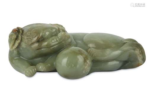 A CHINESE PALE CELADON CARVING OF A LION DOG WITH A BALL.