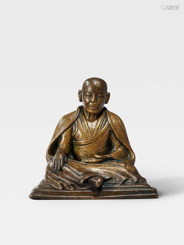 A BRASS FIGURE OF AN ELDERLY LAMA TIBET, CIRCA 14TH CENTURY