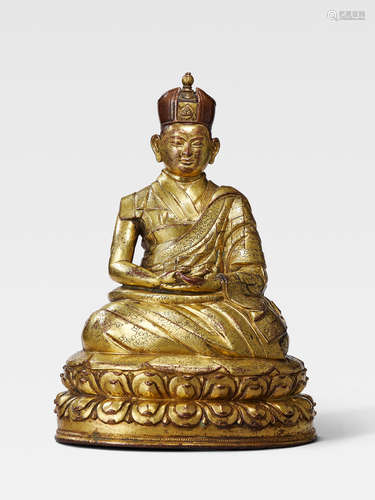 A GILT COPPER ALLOY FIGURE OF THE FIRST SHAMARPA, DRAKPA SENGGE TIBET, CIRCA 16TH CENTURY