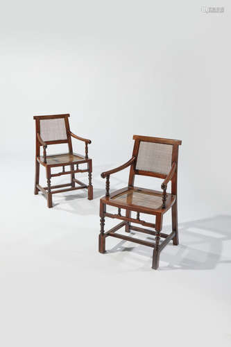 Chinese Export Pair of Armchairs early 20th century probably Shanghai, padouk with cane back and seats, each with loose silk upholstered seat cushion height 34in (86.5cm); width 20in (51cm); depth 20in (51cm)