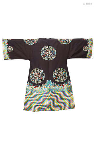 A CHINESE Woman's Black silk embroidered informal surcoat Late 19th century with a center front opening, the black silk ground embroidered with floral roundels, the stylized wave border at the hem repeated at the cuffs 53 1/4in (155cm) long