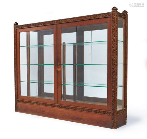 Lockwood de Forest (1850-1932) Bookcase circa 1890 teak, glass, carved by the Ahmedabad Wood Carving Company, Ahmedabad, India, possibly assembled in New York height 63in (160cm); width 78in (198cm); depth 14in (35.5cm)