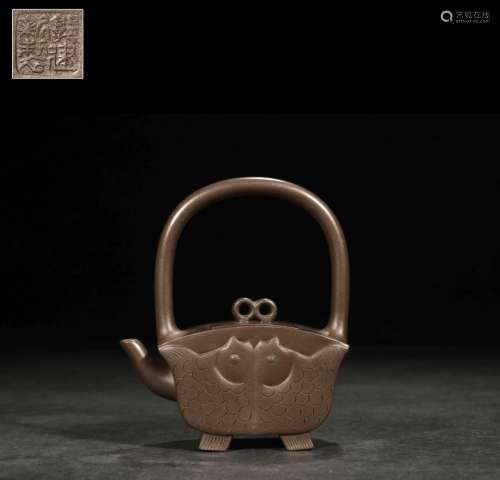 a chinese handled tea pot with fish pattern