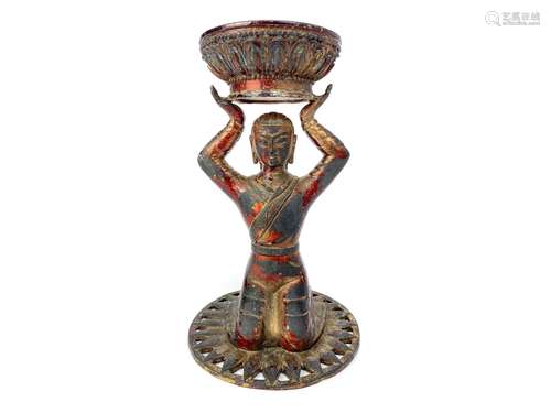 AN EASTERN BRONZE FIGURE OF A KNEELING DEITY HOLDING ALOFT A CIRCULAR VESSEL