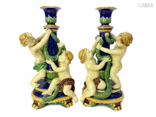 A PAIR OF MINTON MAJOLICA FIGURAL CANDLESTICKS