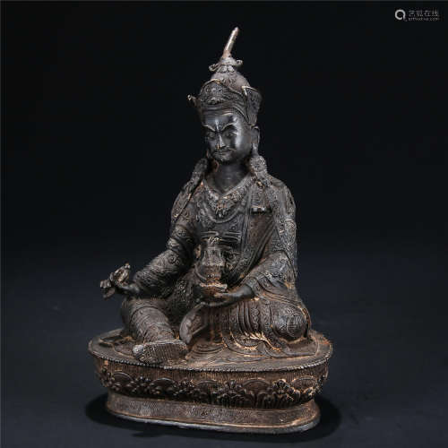 Copper statue of buddha sitting in lotus