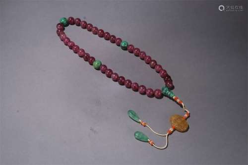 A QING DYNASTY TOURMALINE THIRTY-SIX BEADS HAND STRING