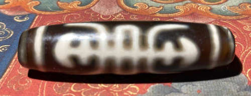 A TIBETAN AUSPICIOUS PATTERN DZI PENDANT