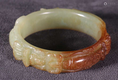 AN ANTIQUE JADE BANGLE CARVED WITH BUDDHA PATTERN