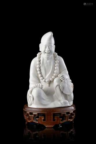 A blanc de chine figure of Jigong, wood base China, 20th century Provenance Milanese private collection Gianni Russo Antiquities (h. 19.5 cm.)...