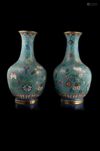 A pair of cloisonné enamel bottle vases, decorated with flowers on blue ground, ruyi motif to the neck and clouds to the bottom China, first half 19th century (h. 34 cm.)...