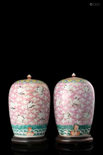 A pair of rose ground jars painted with cranes among clouds, wood bases (leads probably of a later period) (slight defects) China, 19th century (h. 30 cm.)...