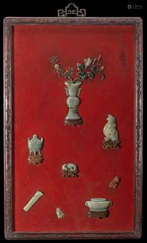 A large red cinnabar panel, incrusted with celadon jades and hard stones depicting a blossoming vase and archaic objects, finely carved hongmu frame China, late Qing dynasty (1644-1911) Provenance Milanese private collection Gianni Russo ...