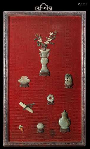 A large red cinnabar panel, incrusted with celadon jades and hard stones depicting a blossoming vase and archaic objects, finely carved hongmu frame China, late Qing dynasty (1644-1911) (98X58 cm.)...