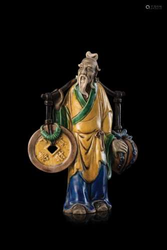 A porcelain figure representing an old man holding a coin and a peach China, 19th century (h. 25 cm.)...