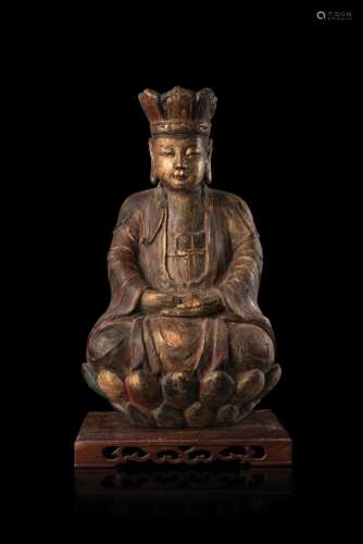 A carved wood seated Buddha, on stand (defects) China, Ming dynasty, 17th century (h. 38 cm.)...