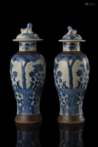 A pair of porcelain jars with covers, decorated with flowers, shrubs and birds (defects) China, late Qing dynasty (1644-1911) (h. max 32 cm.)...
