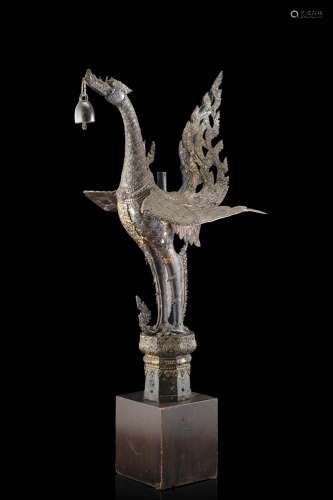 A bronze winged dragon holding a bell, on wood stand (defects and restorations) Southeast Asia, 19th century (h. max 93 cm.)...