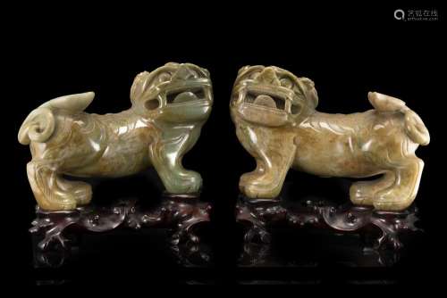 A pair of jadeite lions, wood bases (slight defects) China, 20th century (lungh. max 28 cm.)...
