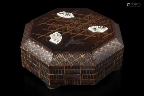 An octagonal lacquered wood box, painted with geomatrical patterns and birds among shrubs, concealing nine trays inside and painted with a view of the Fujiyama under the cover (defects and losses) Japan, Meiji period (1868-1912) (30x30 cm....