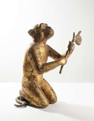 THAÏLANDE, XVIIIème - XIXème siècle. Sculpture en ronde bosse du singe présentant l'essaim d'abeilles. Bronze doré. H. 36 cm. Note : Le singe et l'éléphant sont souvent représentés aux pieds du Bouddha offrant de l'eau pour l'éléphant, du miel pour le singe. Cela fait référence à la période où le Bouddha s'est retiré en forêt et les deux animaux incarnent le bien et le mal : l'éléphant offre de l'eau