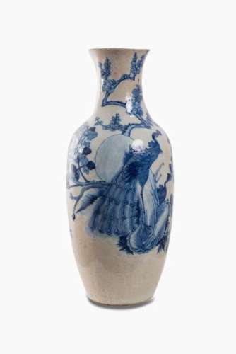 CHINE, Nankin, XVIIIème siècle. Marque de l'empereur Kangxi sous le pied. Vase en porcelaine émaillée et craquelée à décor en camaïeu de bleus sous couverte de paons et branches de prunus et pivoines. H. 57 cm. Eclats au col.