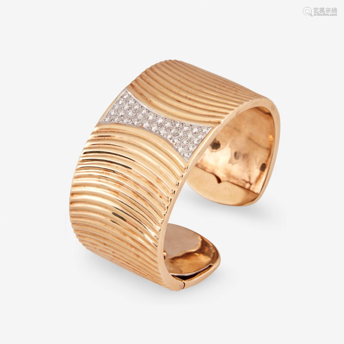 A fourteen karat gold and diamond bangle,